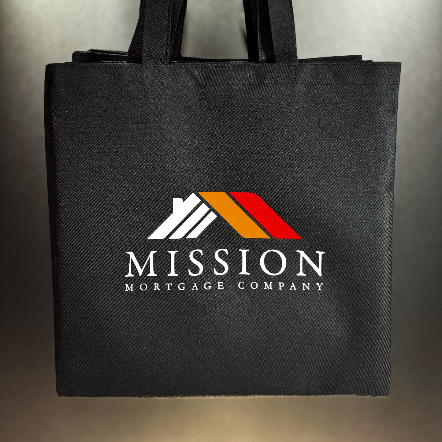 Black canvas tote bag with a custom printed company logo in full color
