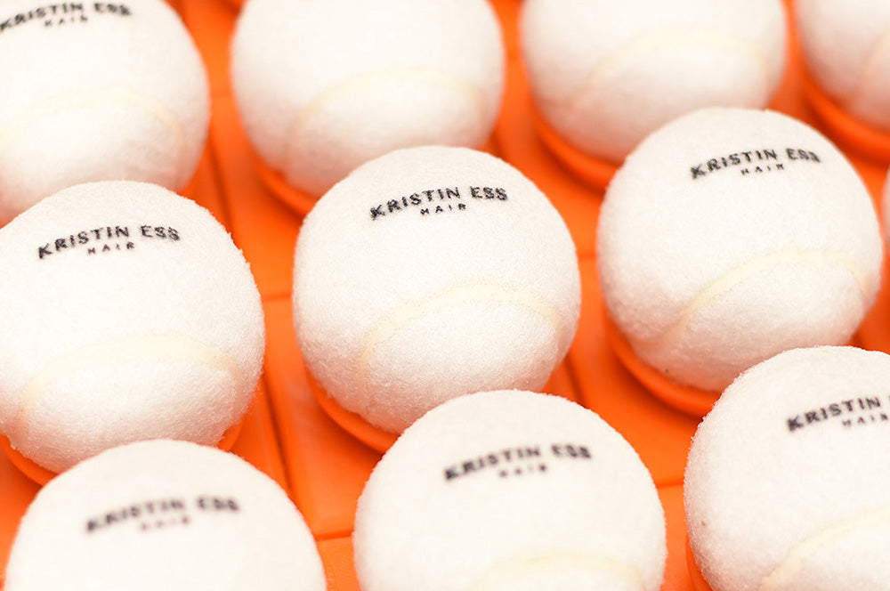 Kristin Ess branded tennis balls, designed for high-end promotional giveaways.