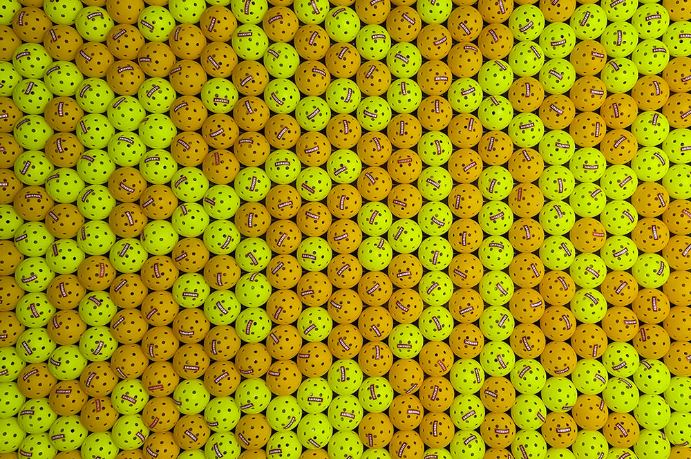 Bulk custom-printed pickleballs for events, featuring personalized logos and text.