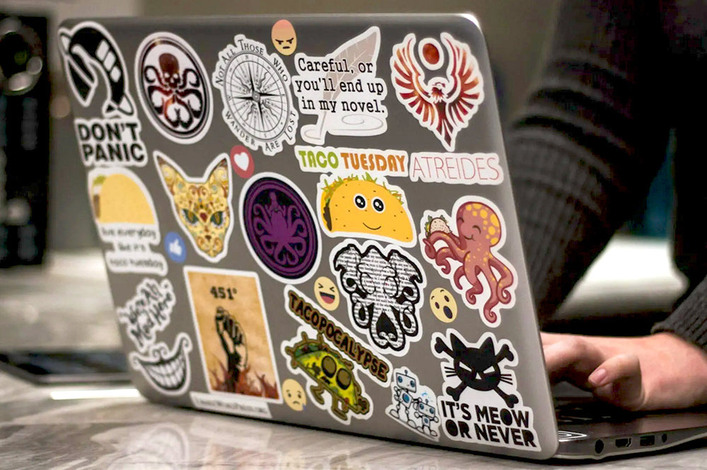 Assorted branded die-cut stickers displayed on a wooden surface, showcasing high-quality cuts.