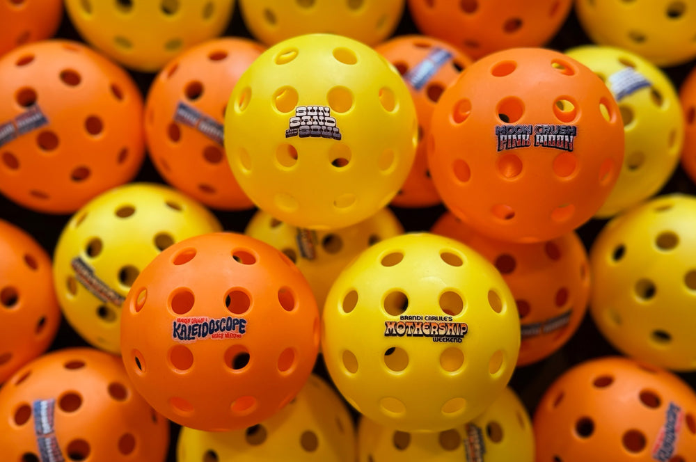 Custom logo printed pickleballs in orange and yellow, perfect for branding and promotions.