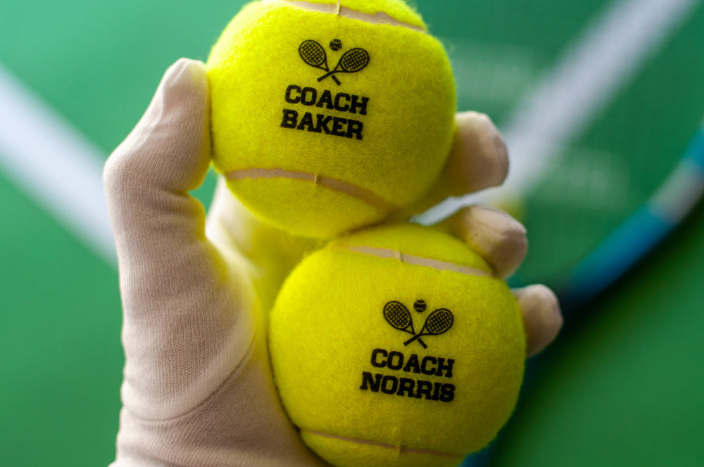 Personalized tennis balls featuring coach names, ideal for gifts and team branding.