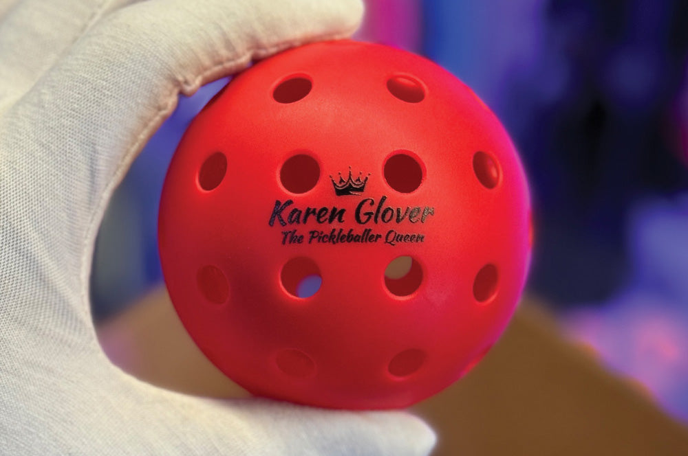 Red pickleball featuring a custom logo and name design for promotional branding.