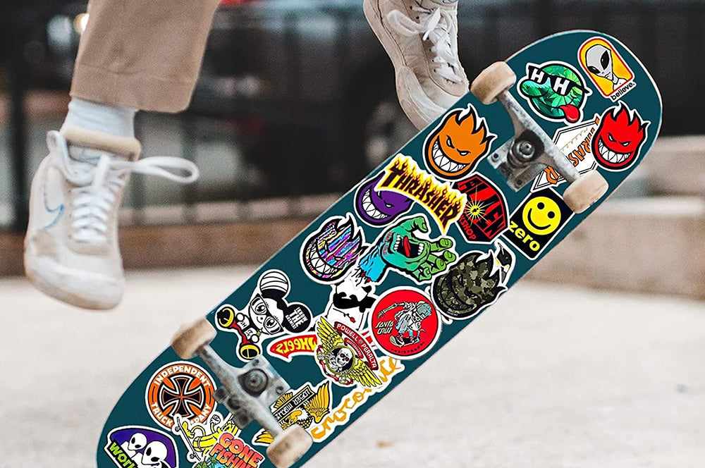Skateboard decorated with multiple custom stickers, showcasing a vibrant and edgy look.