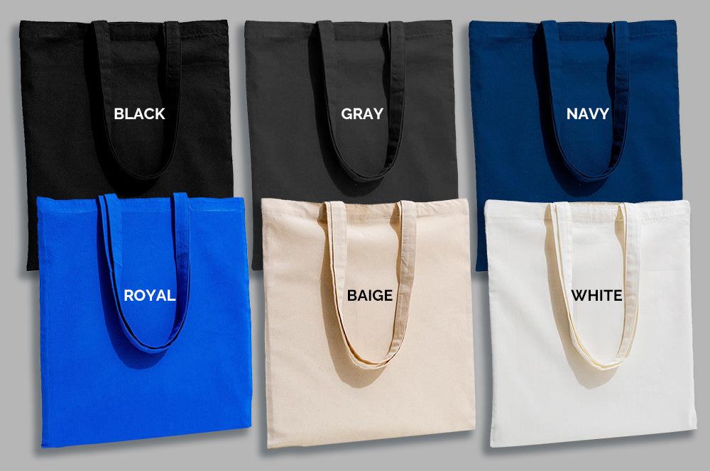 Side-by-side display of six blank tote bags in black, gray, navy, royal blue, beige, and white colors