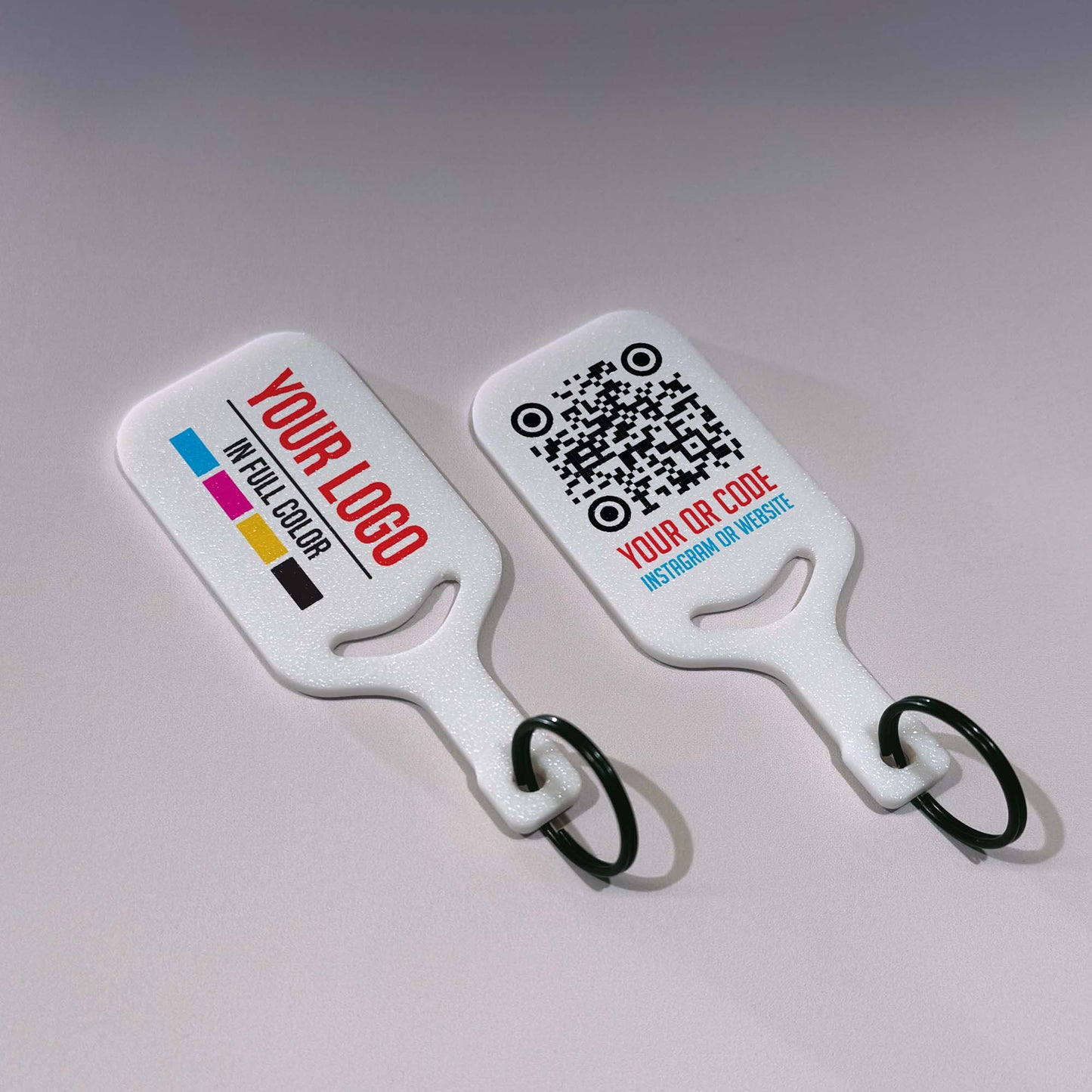 Two white keychains with customizable text and QR code on a gray background